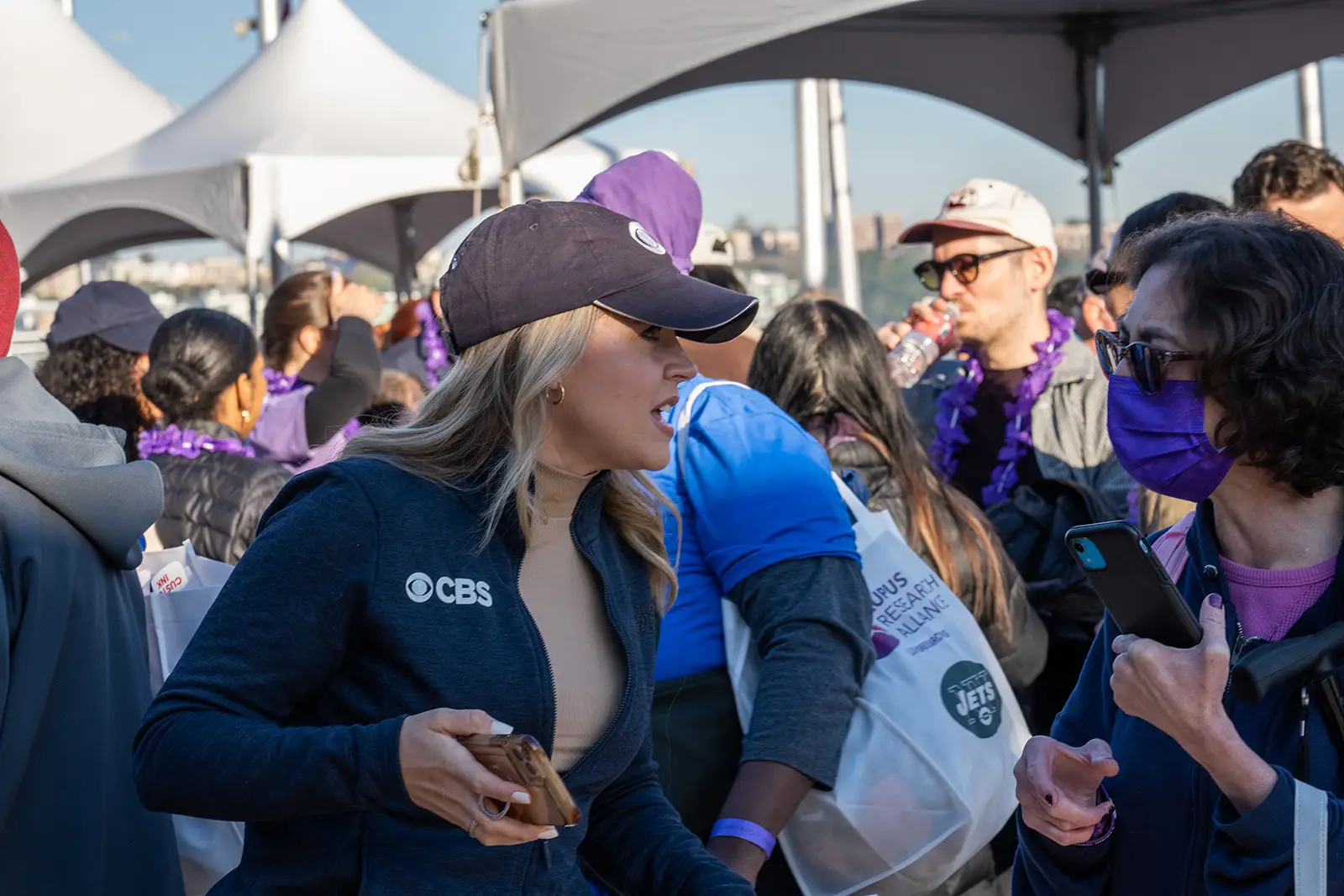 Crowd of participants wearing purple in support of the Lupus Research Alliance at the Lupus Walk fundraiser event in New York City