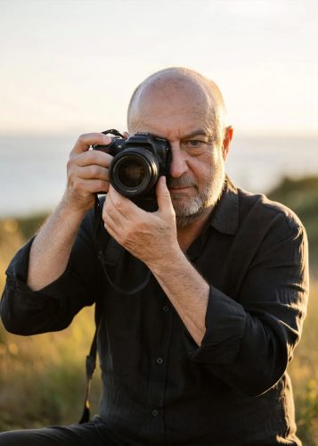 The owner of Photoshoott Photography holding a camera at sunset in New Jersey