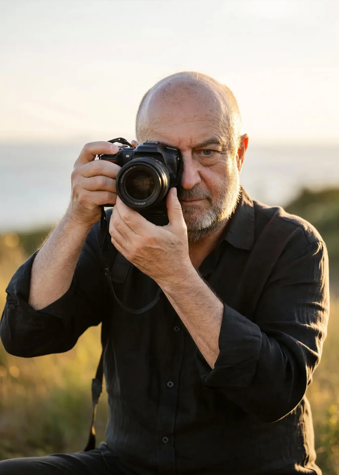 The owner of Photoshoott Photography holding a camera at sunset in New Jersey