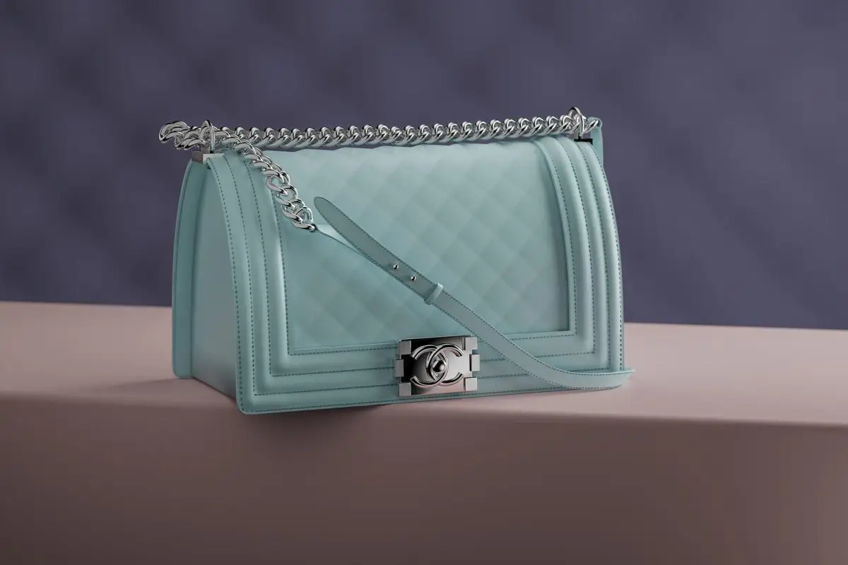 Light blue quilted leather handbag with a silver chain strap on a two-tone studio background