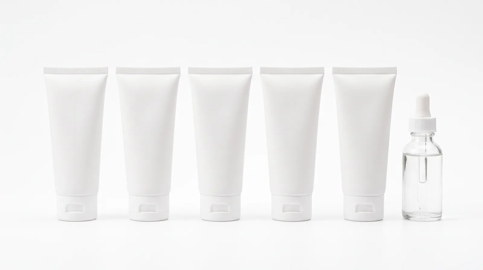 Row of white cosmetic tubes photographed on white for an ecommerce catalog