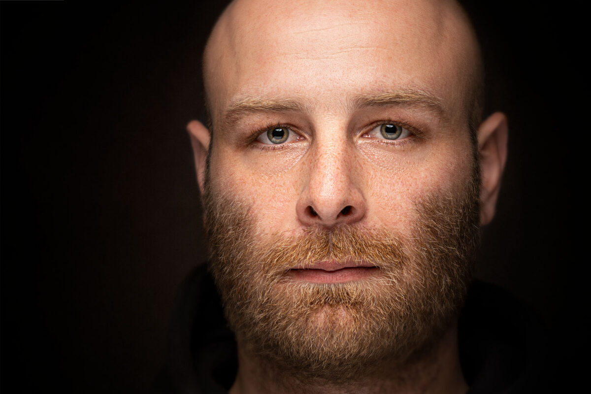 Moody studio portrait of a bearded man on a dark backdrop