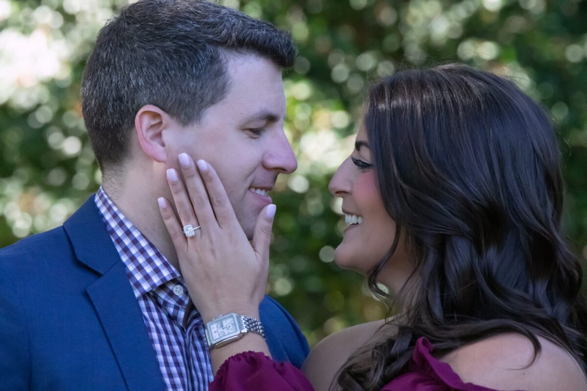 Man gently holding his fiancee's face during an engagement session
