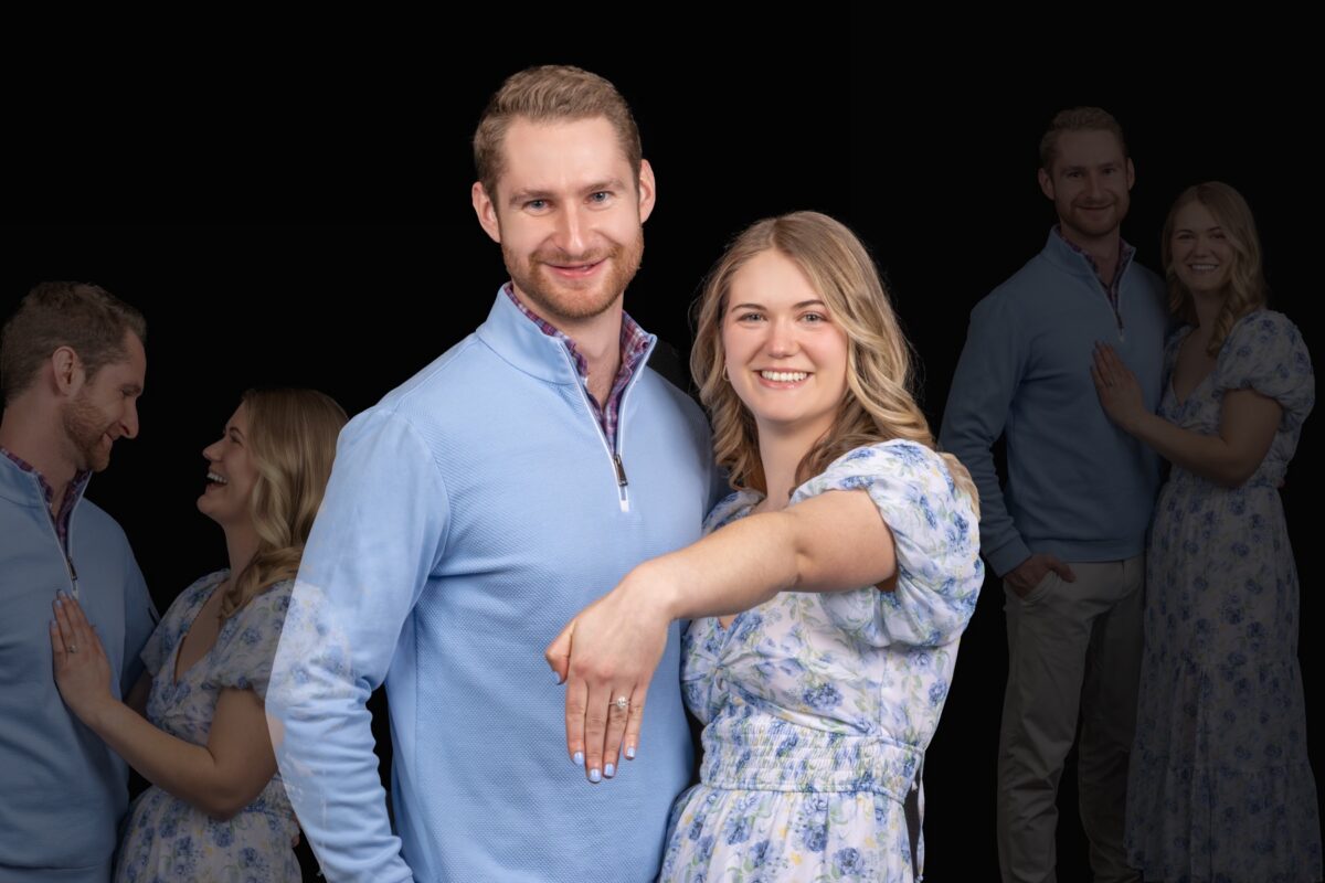 Engaged couple posing on a dark studio backdrop
