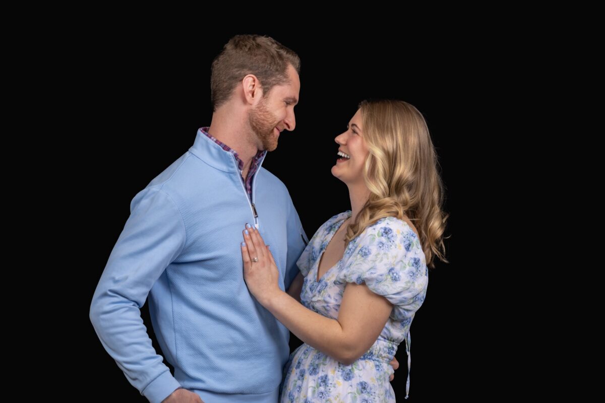 Engagement portrait of a couple on a black backdrop