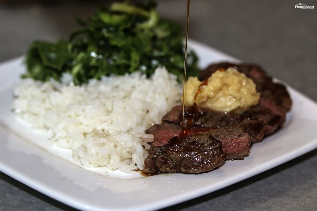 Plated steak with rice and greens