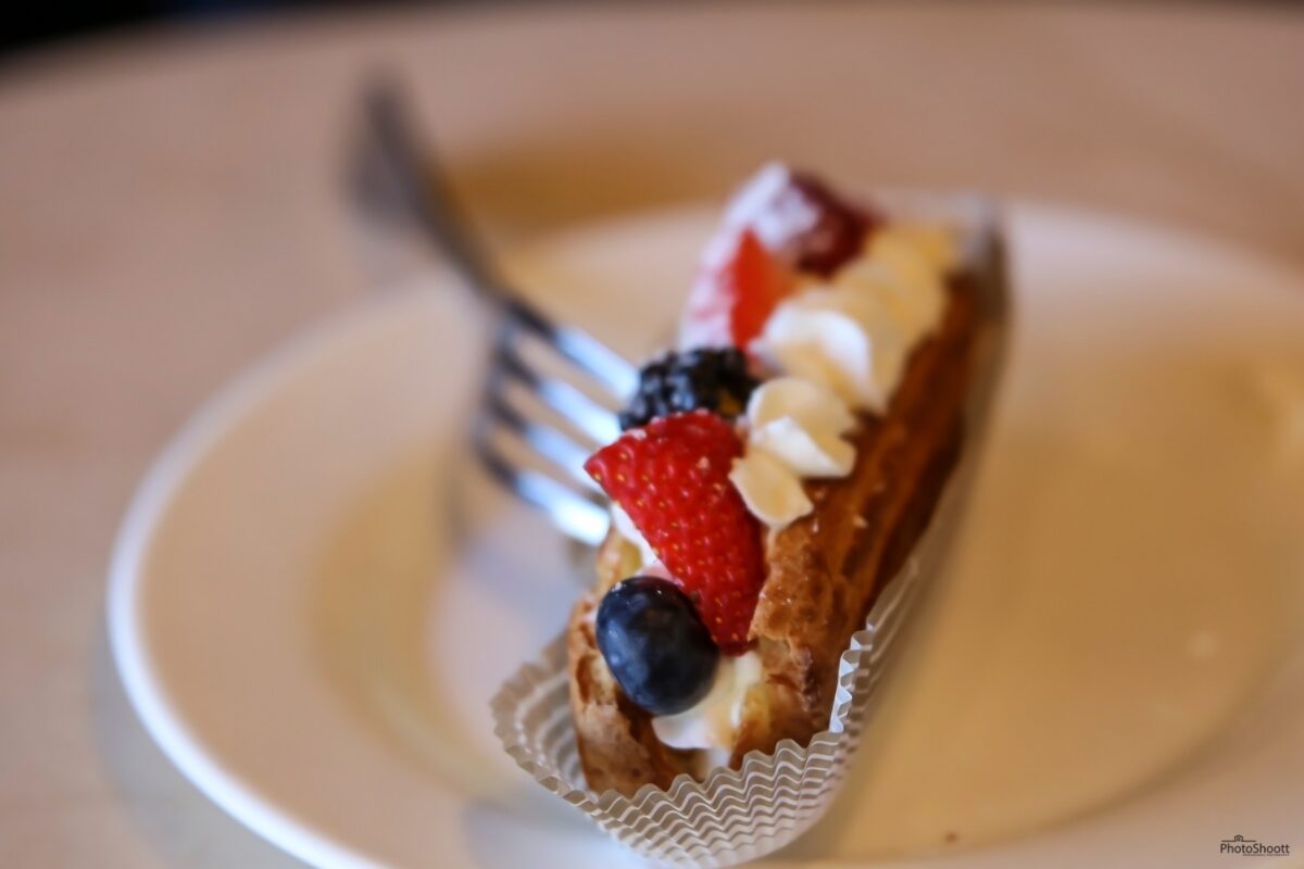 Slice of cake with fresh fruit on a white plate