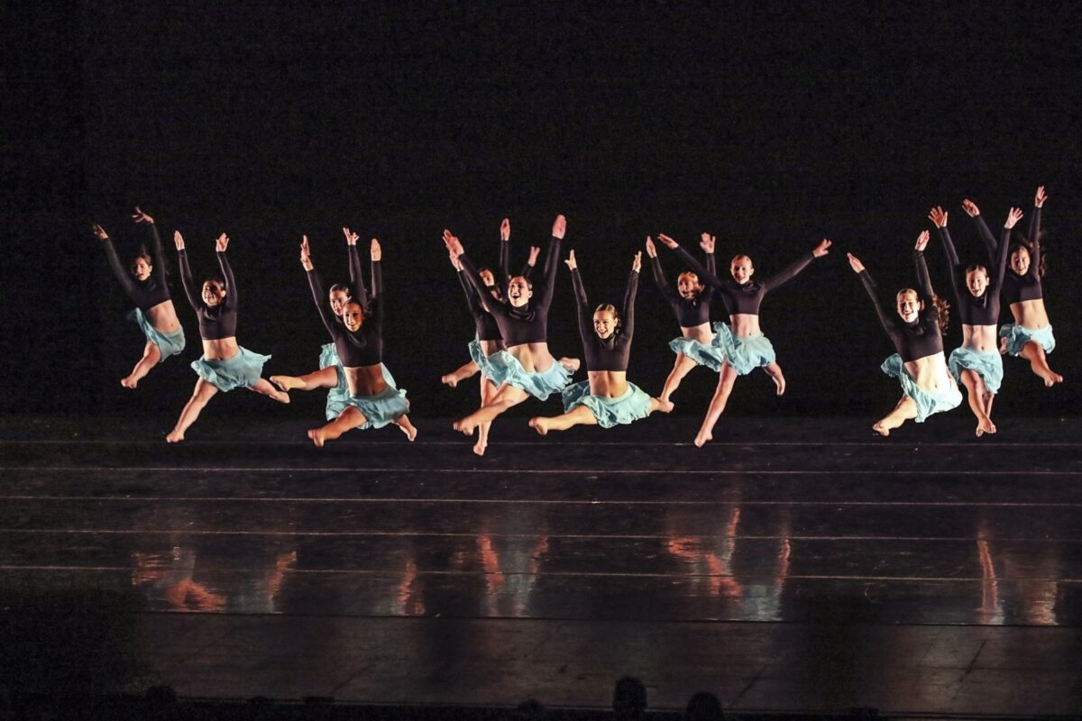 Dancers leaping on stage at an Artistry Dance Project shoot