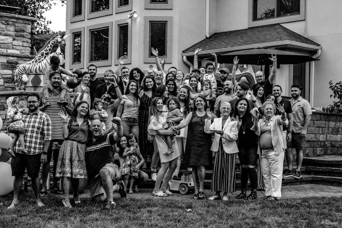 Black and white group photo of guests at a large party