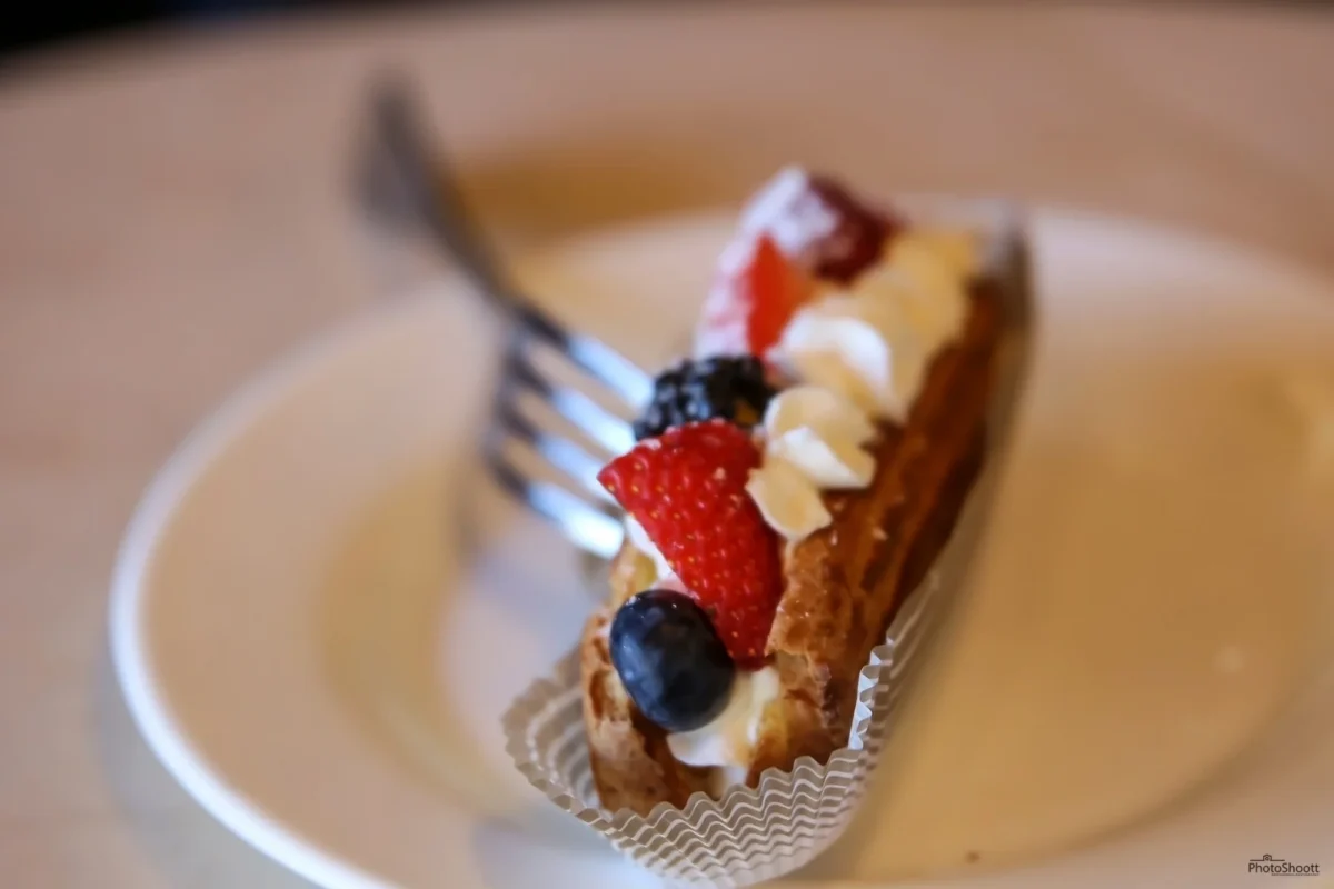 Slice of cake with fresh fruit on a white plate