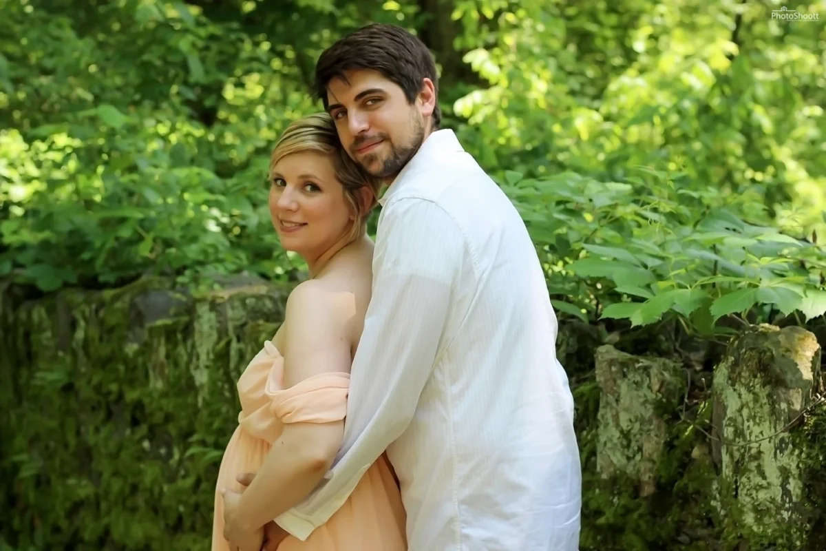 Couple embracing in the woods during a maternity session