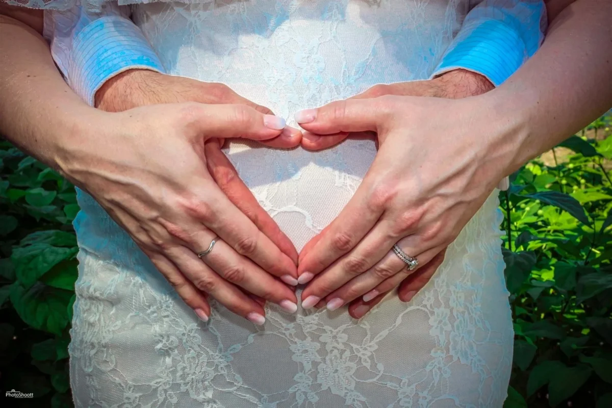 Hands forming a heart over a pregnant belly