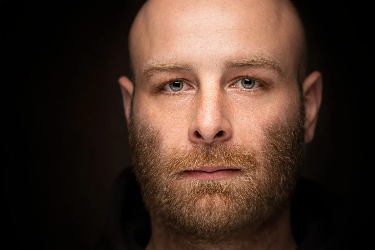 Moody studio portrait of a bearded man on a dark backdrop