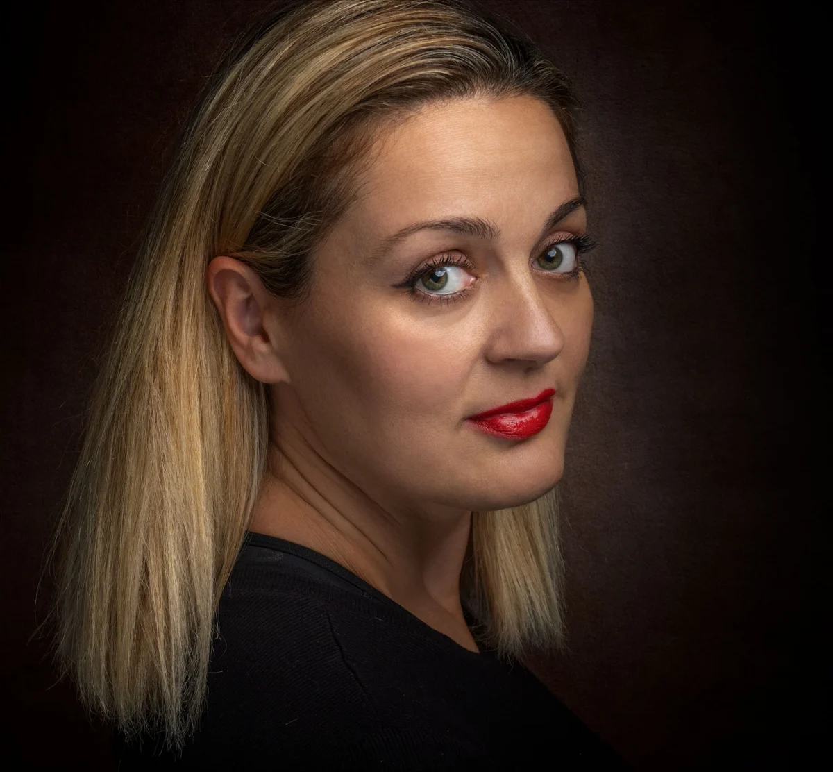 Woman with auburn hair in a dramatic low-key studio portrait