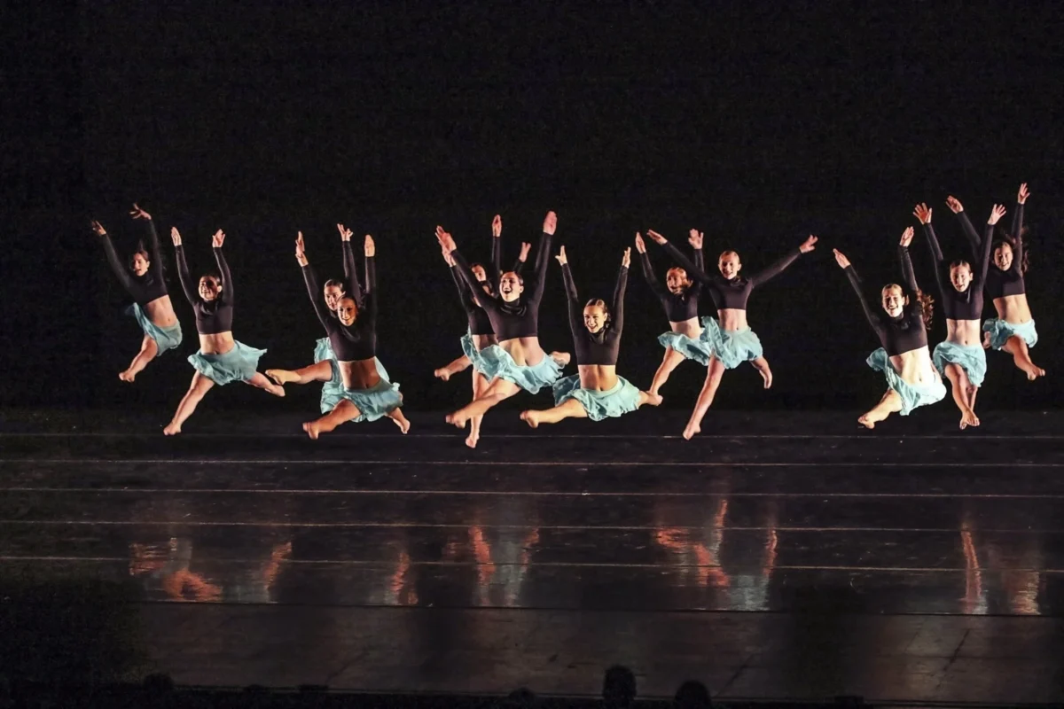 Dancers leaping on stage at an Artistry Dance Project shoot